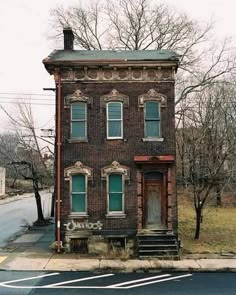 an old brick building sitting on the side of a road