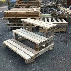 several wooden pallets stacked on top of each other in front of a pile of wood