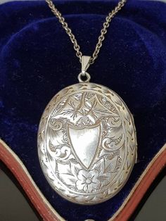 "Gorgeous sterling silver Antique Victorian Aesthetic (circa 1880's, no hallmarks, common in this era, however tested as silver)  ornately engraved double sided locket finely detailed with vacant cartouche in the shape of a shield surrounded by flowers and ivy leaves with decorative border.  To the other side, is a \"greek key meander\" design signifying \"eternity\" again surrounded by decorative ivy leaves and scrolls.  A beautiful piece that looks like it was originally gilded (gold on silver) as it has very slight traces of this which is seen in the photos and can also be worn either way be worn either way around as a new (more modern sterling silver clip loop bail)  allows the owner to choose to change it around to which is side preferred. Opens at the side and closes well to reveal t Antique White Gold Necklace With Intricate Design, Antique Silver Sterling Silver Vintage Locket Necklace, Vintage Hallmarked White Gold Locket Necklace, Antique White Gold Necklaces With Locket, Ornate Engraved Locket Necklace For Formal Occasions, Ornate Engraved Locket Necklace For Formal Events, Victorian White Gold Medallion Necklace, Antique White Gold Necklace With Locket, Antique White Gold Necklace