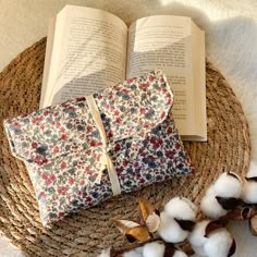 an open book sitting on top of a table next to cotton