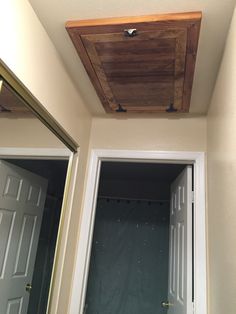 a bathroom with a wooden ceiling and white door frame in the middle of the room