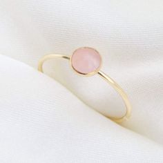 Our delicate Rose Quartz Ring features a pink natural gemstone in a gold filler or sterling silver setting! Rose Quartz is the birthstone for all our October-born babes. Don't know your ring size? Ring Size Guide or Buy Ring Sizer …………………………………. Details: Stone is Natural Rose Quartz, measuring 5mm Available in 14k Gold Filled or Sterling Silver Waterproof and can be worn everyday Size Inclusive and made to order About Your Jewelry If you are not wearing your jewelry it is best to store it in a c Pink Round Stone Promise Ring, Dainty Pink Stackable Promise Rings, Pink Gold Gemstone Rings For Gifts, Rose Gold Rings With Rose Quartz For Gifts, Dainty Pink Crystal Ring For Anniversary, Dainty Pink Crystal Anniversary Ring, Pink Dainty Crystal Ring For Anniversary, Rose Quartz Crystal Ring In Rose Gold, Adjustable Rose Gold Birthstone Ring For Everyday