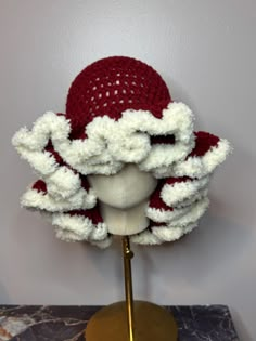 a mannequin's head wearing a red and white crocheted hat