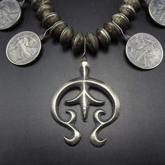 "VINTAGE NAVAJO MERCURY DIME & STANDING LIBERTY COIN SILVER NECKLACE DESCRIPTION: This outstanding necklace features 48 Mercury Dime beads (for a total of 96 dimes), and 8 well-defined Standing Liberty half dollar coins (1936, 1941, 1942, 1943, 1944 x 2, 1945, 1946). The sand cast naja features fleur de lis and flared terminal. This impressive old necklace will be a valuable addition to your collection of fine vintage Native American jewelry. MEASUREMENTS: Necklace measures 21 1/2\" end to e Vintage Pendant Coin Necklace With Charm, Vintage Charm Pendant Coin Necklace, Vintage Necklace With Coin Pendant, Silver Necklaces With Coin Pendant For Vintage Collection, Vintage Coin Necklaces, Handmade Silver Vintage Medallion Necklace, Antique Collectible Necklaces With Round Beads, Vintage Silver Coin Necklace With Charm, Silver Vintage Charm Coin Necklace