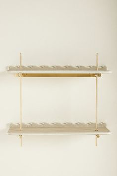 two white shelves with gold handles on each shelf and one has a long bar at the top