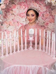 a woman sitting at a table surrounded by candles