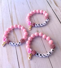 "This super sweet pink beaded ballet bracelet is the perfect gift for a dancer! These have been very well received and a favorite of all the dancers we know! The custom name bracelet can be made with the dancer's name, dance team, or even \"dance\" or \"ballet\". Be sure to put the name you would like in the ... section. Each bracelet comes with a pink organza drawstring bag and is ready for gifting! If you are unable to measure the dancer's wrist, just use our age guide in the drop down menu. We also have lots of other ballet themed items in our shop, so be sure to check those out as well!  Every purchase made at OhSheDances goes directly towards funding a young dancer's dreams. We appreciate you stopping by!" Recital Gifts For Dancers, First Dance Recital Gift, Dance Team Gifts Bracelets, Personalized Dance Gifts, Gifts For Ballet Dancers, Dance Recital Gifts, Dance Team Gifts, Ballerina Jewelry, Ballerina Gift