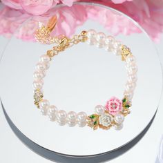 Adorn your wrist in natural elegance with the Wild Rose Pearl Bracelet. Delicate pink roses, each petal intricately engraved, entwine to form the band encasing shimmering freshwater pearls. Enamel in rich shades of green leaf and rosy floral hues brings the English countryside to mind. Light and lovely, this piece offers far more than meets the eye with its carefully crafted floral charm. Subtle and sweet, it brings beauty and delight to every occasion. DETAILS Plating: 18K Gold Materials: 18K G Elegant Gold Beaded Bracelet With Flower Charm, Elegant Rose Colored Bracelet, Delicate Pink Bracelets For Wedding, Delicate Pink Bracelet For Wedding, Elegant Rose Gold Bracelets With Flower Charm, Elegant Rose Gold Bracelet With Flower Charm, Elegant Rose Jewelry For Mother's Day, Elegant Rose Design Bracelets For Wedding, Elegant Rose Design Bracelet For Wedding