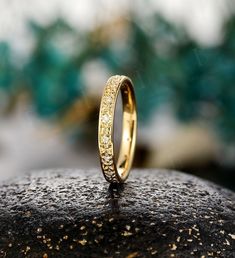 a close up of a wedding ring on top of a rock