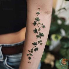 a woman's arm with green ivy leaves on the left side of her arm