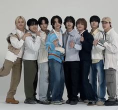 a group of young men standing next to each other in front of a white background