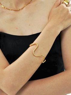 Wavy Open Cuff Bracelet in 18k Gold-Plated, featuring a fluid, organic design, perfect for adding a dynamic and modern touch. Modern Twist Cuff Bracelet For Formal Occasions, Modern Party Cuff Bangle Bracelet, Elegant Open Cuff Bracelets For Party, Modern Wavy Jewelry For Formal Occasions, Elegant Irregular Jewelry For Party, Modern Twist Cuff Bracelet Bangle For Formal Occasions, Modern Twist Bangle Cuff Bracelet For Formal Occasions, Elegant Adjustable Wavy Bracelets, Elegant Bangle Bracelets With Unique Design