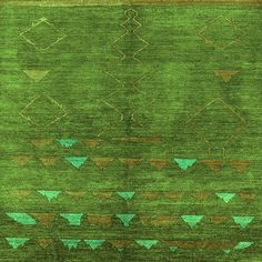 an area rug with green and brown designs on the ground, including two rows of triangles