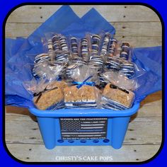 a blue container filled with cookies and other items on top of a wooden table next to a flag