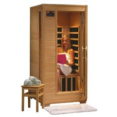 a person in a sauna with the door open and a table next to it