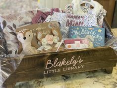 a wooden crate filled with baby items on top of a table