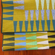 a quilted table runner on top of a wooden floor