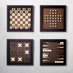 four pieces of wood are arranged in squares and checkers on a white wall behind them