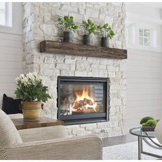 a living room filled with furniture and a fire place next to a wall mounted fireplace