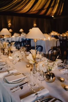 the table is set with silverware and white flowers