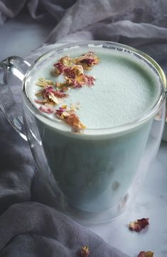 a glass mug filled with liquid and dried flowers