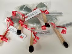 four wooden spoons wrapped in plastic and tied with red ribbon