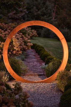 a circular sculpture in the middle of a garden