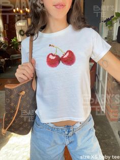 Pixelated Cherry Baby Tee 100% cotton baby tee    ✺ This is a miniaturized boxy baby t-shirt, different from modern crop tops, and it typically fits true to size. Please see the size chart before purchase for the perfect fit <3 ✺ ❣︎ Custom Tee! Love the vibe, but don't see exactly what you want? Send a message my way! I'd love to create something custom for you. ❣︎ ❁ 0% to the landfill! We use a sustainable, high-quality printing process. ❁ ✧ Artist designed! By shopping at Baby's Tee, you support my small biz. Love that! ✧ Shop Policies: ❥ Each item is made to order. Please allow 2-5 business days for the shipping of your product. ✺ No Returns: Due to our print-on-demand process, we do not accept returns. Please carefully review the sizing chart provided to ensure the perfect fit. ☺︎ If y Baby Tee Aesthetic, Y2k Cherry, Baby Tee Shirt, Baby Tee Shirts, Shirt Coquette, Cherry Baby, Baby Tees Y2k, Custom Tee, Style Box