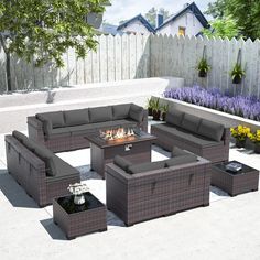 an outdoor fire pit surrounded by wicker furniture