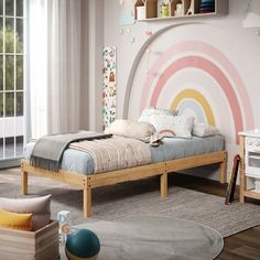 a child's bedroom with a rainbow wall mural