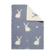 a blue blanket with white rabbits on it