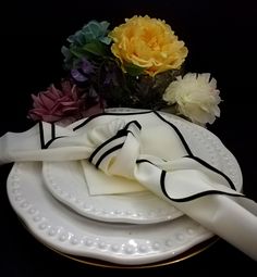 a white plate with napkins and flowers on it