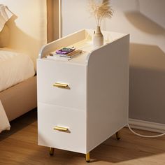 a white bedside table with two drawers and a phone on top, next to a bed