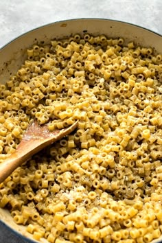 macaroni and cheese in a skillet with a wooden spoon