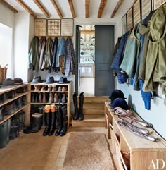 the inside of a shoe store with lots of shoes and coats hanging on hooks,