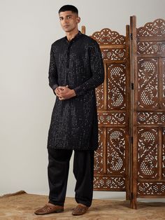 Vastramay Men's Black Mirror Georgette Kurta With Patiala Set Make a statement in this elegant black kurta with a stylish mirror work design. The georgette fabric adds a touch of luxury, perfect for festive occasions or special events. Features: Black georgette kurta with mirror work Patiala set for a complete traditional look Comfortable and stylish Specifications: Brand: VASTRAMAY Color: Black Fabric: Georgette Neck: Mandarin Collar Sleeve Length: Full Sleeves Material & Care: Georgette, Dry-c Designer Kurta With Mirror Work For Festive Occasions, Designer Festive Kurta With Mirror Work, Designer Straight Kurta With Mirror Work, Designer Kurta With Mirror Work For Eid, Designer Mirror Work Kurta For Diwali, Designer Eid Kurta With Mirror Work, Long Sleeve Kurta With Mirror Work For Party, Designer Sequined Kurta For Festive Occasions, Transitional Black Sherwani With Cutdana