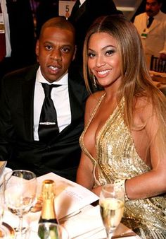 two people sitting next to each other at a dinner table with wine glasses in front of them