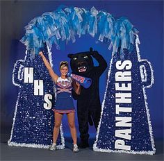 a woman standing next to a black bear in front of a blue sign that says pantheres