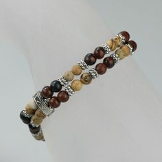 This double strand bracelet is handmade using the semi precious stone Picture Jasper. Picture Jasper is a grounding and harmonizing stone with a strong connection to the earth. It promotes feelings of responsibility towards the planet, encouraging a need to care for and protect it. The length of the necklace is 7-8 1/4 inches, 18-21cm. Brown is a color of physical comfort, simplicity and quality. It gives reassurance. It is quietly confident but never the life of the party! Brown does not seek a Elegant Wrap Bracelet With Natural Stones As A Gift, Elegant Adjustable Wrap Bracelet With Natural Stones, Brown Stackable Beaded Bracelets Gift, Gift Stackable Brown Beaded Bracelets, Gift Brown Stackable Beaded Bracelets, Elegant Brown Wrap Bracelet As A Gift, Brown Gemstone Beads Bracelet As Gift, Spiritual Jasper Beaded Bracelets As Gift, Stackable Agate Jewelry For Gifts