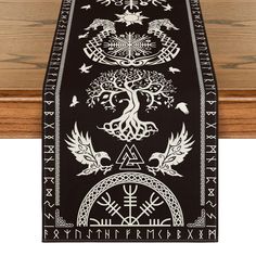 a black table runner with white designs on it and an image of a tree of gondol