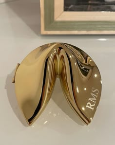 a close up of a gold object on a white surface