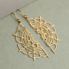 These gold earrings feature a bohemian filigree lace design in solid brass.  The beautiful, intricate detail reminds us of vintage lace and has been hand designed in our Edinburgh studio.   The ear wires are gold plated brass, and the length of these earrings is 40mm, with the lace semi circles designed to hang just below the earlobe.   This piece of handmade jewellery comes packaged in a nice recycled gift box with a handmade tag, all ready to give or keep. 🖤 FASTER SHIPPING 🖤 Need this fast? Gold Brass Plug Earrings For Wedding, Gold Threader Earrings For Gift, Festive Gold Brass Plug Earrings, Gold Teardrop Threader Earrings, Gold Teardrop Threader Pierced Earrings, Gold Dangle Threader Earrings Nickel Free, Gold Brass Threader Earrings As Gift, Gold Brass Plug Earrings With Intricate Design, Gold Pierced Plug Earrings For Festive Occasions