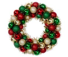 a christmas wreath with red, green and gold ornaments on it's side against a white background