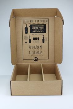 an open cardboard box with three bottles in it and labels on the inside, sitting on a white surface