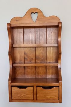 a wooden shelf with two drawers and a heart on the top