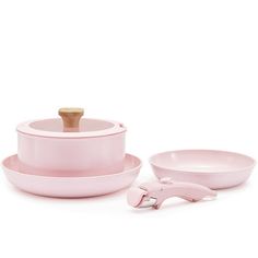 a set of pink dishes and utensils on a white background