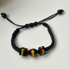 Feel the island vibes with this adjustable braided cord and reggae rasta beads bracelet for him or/and for her! This stylish bracelet is made with a high-quality cord that was hand braided and can be adjusted to fit any wrist size. The bracelet is adorned with colourful rasta beads, inspired by the Rastafarian movement and reggae music. Here are some of the features of this bracelet: *Adjustable braided cord for a perfect fit *Colourful rasta beads in red, green, and yellow *Lightweight and comfortable to wear. *Makes a great gift for yourself or a friend. This bracelet is perfect for anyone who loves reggae music, or Rastafarian culture, or simply wants to add a pop of colour to their outfit. Product details: *Material: waxed cord, rasta beads *Colour: Red, green, yellow *Size: Adjustable Casual Rainbow Bracelets With Sliding Knot, Adjustable Rainbow Bracelets For Festivals, Casual Rainbow Beaded Bracelets With Sliding Knot, Adjustable Rainbow Braided Bracelets For Festivals, Casual Rainbow Friendship Bracelets With Sliding Knot, Casual Rainbow Jewelry With Adjustable Cord, Adjustable Rainbow Braided Bracelet For Festival, Casual Resizable Braided Bracelets With Round Beads, Casual Rainbow Bracelets With Adjustable Cord