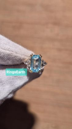 a ring with an aqua blue topaz surrounded by diamonds