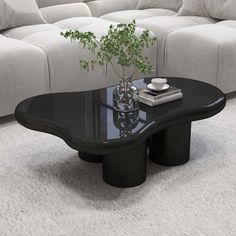 a black coffee table sitting on top of a white carpeted floor next to a couch