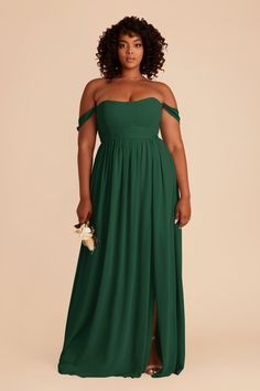 a woman in a long green dress with an off the shoulder top and side slit